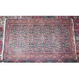 A PERSIAN RUG with multi design centre in reds and blues within a multi-border. 5ft 5ins x 3ft