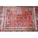 A PERSIAN RUG with floral motifs and multi-border. 4ft 9ins x 3ft 6ins.