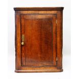 AN 18TH CENTURY OAK CORNER CUPBOARD with panel door opening to reveal three shelves. 3ft high.