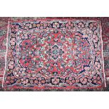 A PERSIAN RUG with red and blue floral pattern and central motif. 5ft 4ins x 3ft 8ins.