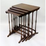 AN EDWARDIAN MAHOGANY NEST OF FOR TABLES on turned legs. Largest 1ft 10ins wide.