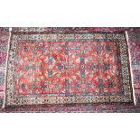 A PERSIAN RUG with large central red and blue pattern within a triple row border. 6ft 7ins x 4ft