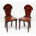 A PAIR OF VICTORIAN MAHOGANY HALL CHAIRS with oval backs and solid seats.