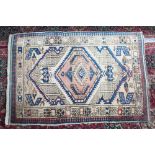 A PERSIAN RUG with central motif, small motifs to the border. 3ft 11ins x 2ft 7ins.