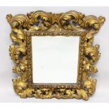 A 19TH CENTURY ITALIAN CARVED GILTWOOD MIRROR with acanthus scrolled frame. 2ft high, 1ft 9ins