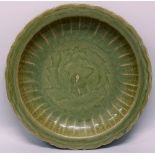 A LARGE CHINESE MING STYLE LONGQUAN CELADON STONEWARE CHARGER, with a barbed edge rim, the