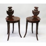 A GOOD PAIR OF REGENCY MAHOGANY HALL CHAIRS, with carved backs, solid circular seats, on curving