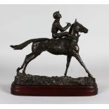 A BRONZE HORSE AND JOCKEY. Signed, on a wooden base. 14ins long.