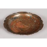 AN EARLY ISLAMIC METAL CIRCULAR DISH with engraved decoration. Islamic script to the reverse. 9ins