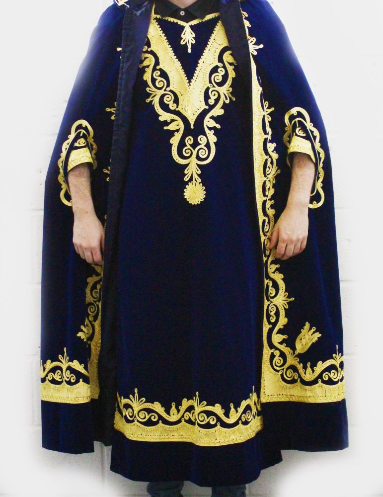 A ROYAL BLUE VELVET WITH GOLD BROCADE EVENING DRESS AND CAPE.