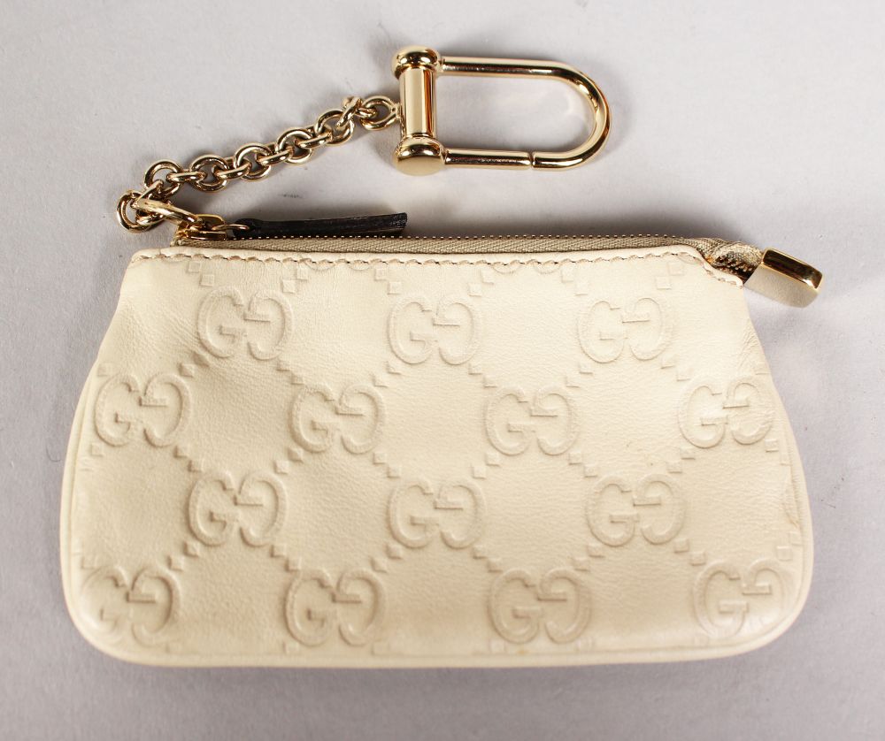 A GUCCI SMALL CREAM PURSE and A GUCCI SMALL YELLOW LEATHER WALLET