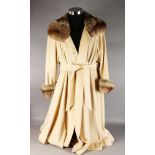A FULL LENGTH CREAM CASHMERE COAT with fox fur collar and cuffs, size L.