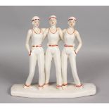 AN ART DECO DESIGN RED AND WHITE GROUP OF THREE GIRLS on a rectangular base. 11ins high.