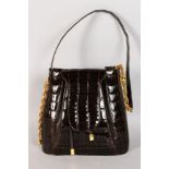 A BROWN LEATHER CROCODILE STYLE HANDBAG with gold hardware.