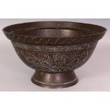 AN EARLY 20TH CENTURY CHINESE BRONZE BOWL, the sides engraved with dragons and waves, the base