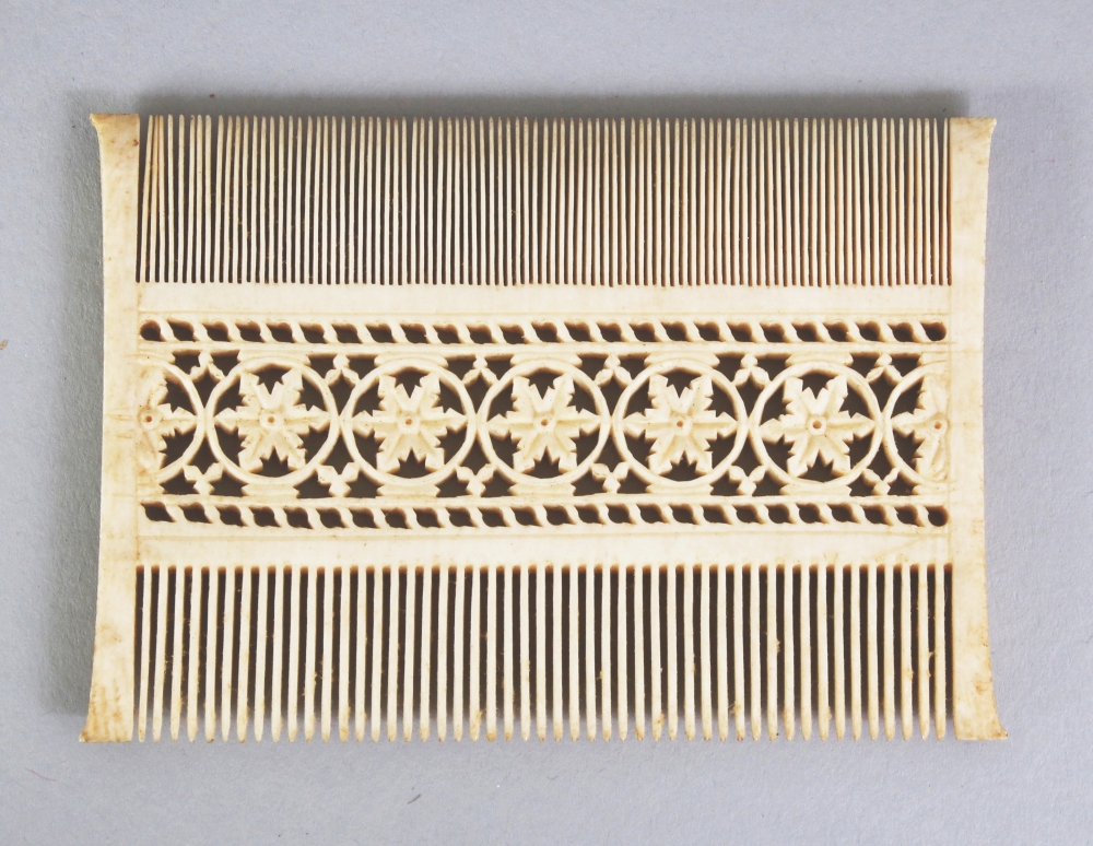 A GOOD QUALITY EARLY 20TH CENTURY EASTERN IVORY COMB, with pierced floral decoration, 3.25in wide