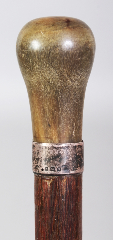 ANOTHER RHINO HORN HANDLED WOOD CANE, with a plain hallmarked silver collar, the shaped rhinoceros