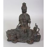 A CHINESE MING STYLE BRONZE GROUP OF GUANYIN, seated on a Buddhistic Lion, 8in wide & 9in high.