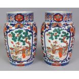A PAIR OF EARLY 20TH CENTURY JAPANESE IMARI PORCELAIN VASES, each painted with panels of two boys in