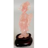 A CHINESE ROSE QUARTZ FIGURE OF A FEMALE IMMORTAL, together with a fitted wood stand, the deity