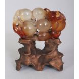 A SMALL 20TH CENTURY CHINESE AGATE CARVING OF LEAF SHROUDED FRUIT, together with a fitted wood