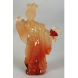 A CHINESE AGATE FIGURE OF A STANDING LADY, holding a flower spray, 4in high.