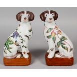 A MIRROR PAIR OF CHINESE PORCELAIN MODELS OF SEATED DOGS, each decorated with butterflies and