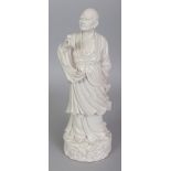 A 19TH/20TH CENTURY CHINESE BLANC-DE-CHINE PORCELAIN FIGURE OF A SAGE, standing on a wave form