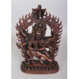 A TIBETAN BRONZE MODEL OF MAHAKALA EMBRACING HIS CONSORT, on a lotus plinth before a flaming