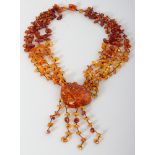 AN AMBER NECKLACE, weighing approx. 85gm, with four strands supporting a large peach-shaped