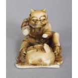 A SMALL SIGNED JAPANESE MEIJI PERIOD IVORY NETSUKE OF A SEATED ONI DEMON MASK MAKER, the base with