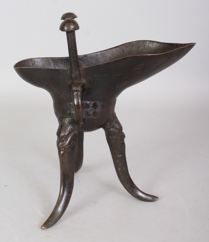 A GOOD CHINESE MING DYNASTY BRONZE JUE TRIPOD CENSER, weighing 810gm, the curved triangular-