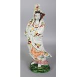 A JAPANESE KUTANI PORCELAIN FIGURE OF KWANNON, standing in swirling robes on a rockwork plinth,