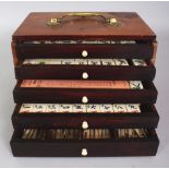 AN EARLY 20TH CENTURY CHINESE BONE & BAMBOO MAH JONG SET, contained in a wood box with sliding
