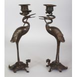 A PAIR OF JAPANESE MEIJI PERIOD BRONZE CANDLESTICKS, each in the form of a stork standing on the