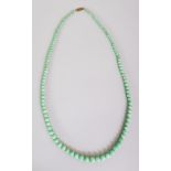 A CHINESE APPLE-GREEN JADE NECKLACE, composed of graduated spherical beads, approx. 27in long.