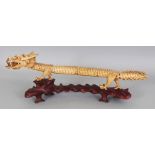 AN EARLY 20TH CENTURY JAPANESE ARTICULATED BONE MODEL OF A DRAGON, together with a fitted wood