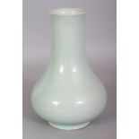 A CHINESE CELADON GLAZED PORCELAIN VASE, the sides applied with a pale even glaze, the base with a