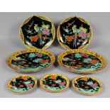 A GROUP OF SEVEN JAPANESE KUTANI STYLE BLACK GROUND FAMILLE ROSE PORCELAIN DISHES, decorated with