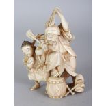 A JAPANESE MEIJI PERIOD IVORY OKIMONO OF A STREET PERFORMER, attended by his son and with numerous