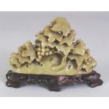 AN EARLY/MID 20TH CENTURY CHINESE CELADON GREEN SOAPSTONE CARVING OF LEAF SHROUDED FRUITING VINE,