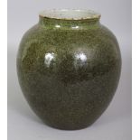 AN UNUSUAL CHINESE PORCELAIN JAR, applied with a green black-speckled glaze, the base unglazed, 6.