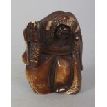 AN EARLY 20TH CENTURY JAPANESE STAINED IVORY NETSUKE OF A ROBED DEMON, with long hair and fierce