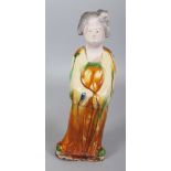 A CHINESE TANG STYLE GLAZED CERAMIC FIGURE OF A STANDING LADY, her robes glazed in ochre and