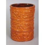 A CHINESE OCHRE GLAZED IMITATION BAMBOO PORCELAIN BRUSHPOT, the sides moulded with bands of