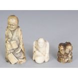 A SMALL JAPANESE MEIJI PERIOD BONE IVORY NETSUKE OF A KNEELING MAN WITH A DARUMA DOLL, 1.75in