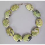 AN UNUSUAL CHINESE GREEN HARDSTONE NECKLACE, composed of large flattened oval beads, the stones with