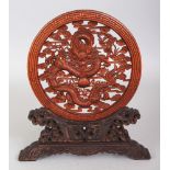 A CHINESE WOOD TABLE SCREEN & STAND, the circular screen pierced with a dragon amidst clouds and