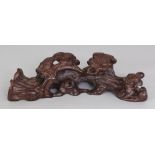 A CHINESE WOOD BRUSH REST, decorated in pierced high relief with pine, 7.8in wide.