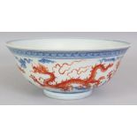 A CHINESE MING STYLE UNDERGLAZE-BLUE & IRON-RED PORCELAIN DRAGON BOWL, 8.6in diameter & 3.6in high.